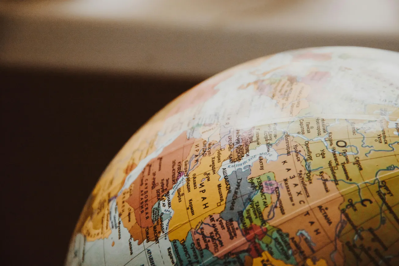 A close-up of a globe, focusing on Europe and parts of Asia and Africa. The map's colors are warm with clear labels.