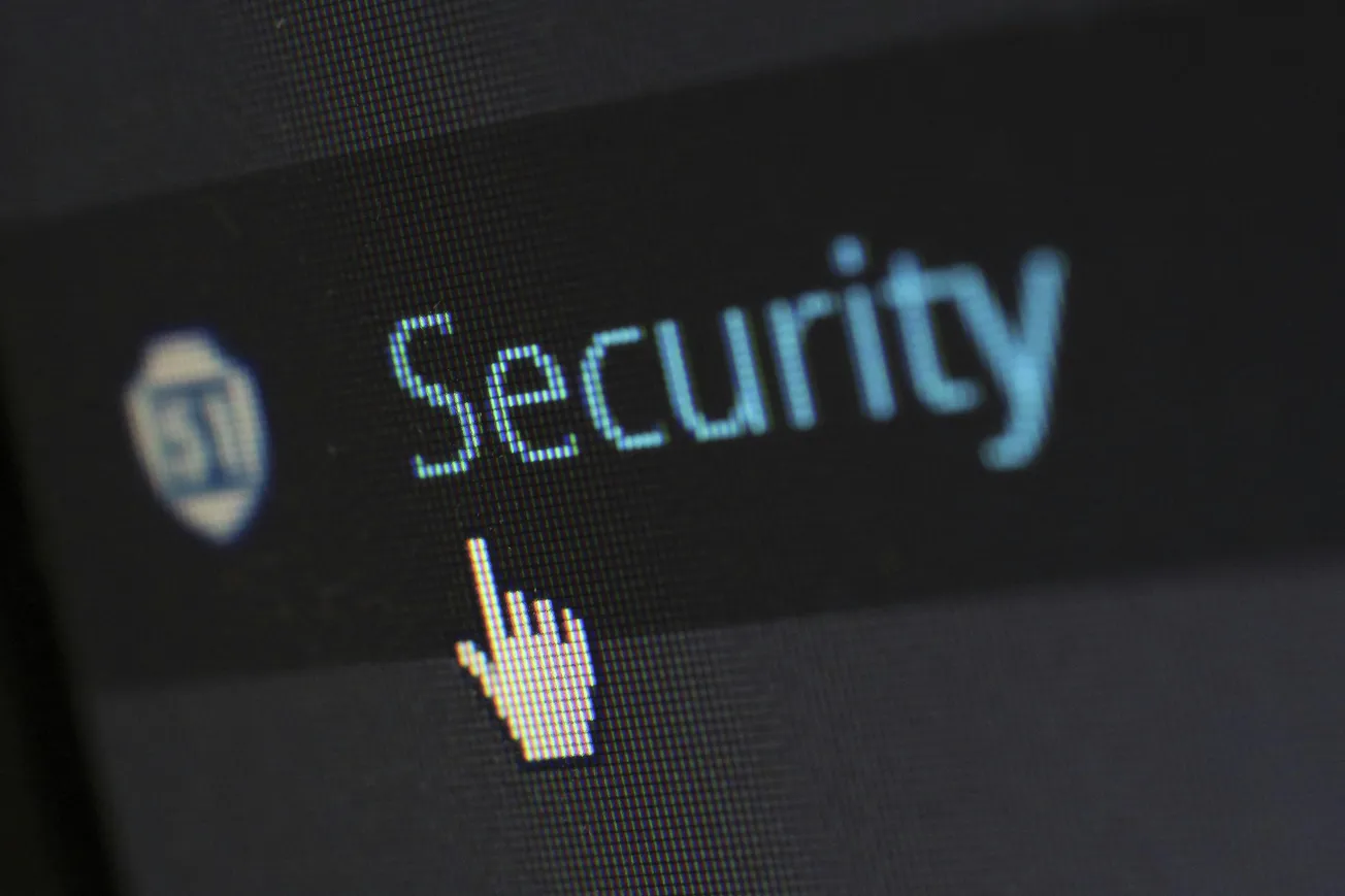 Cursor pointing at the word "Security" on a computer screen, conveying a focus on digital safety and cybersecurity.