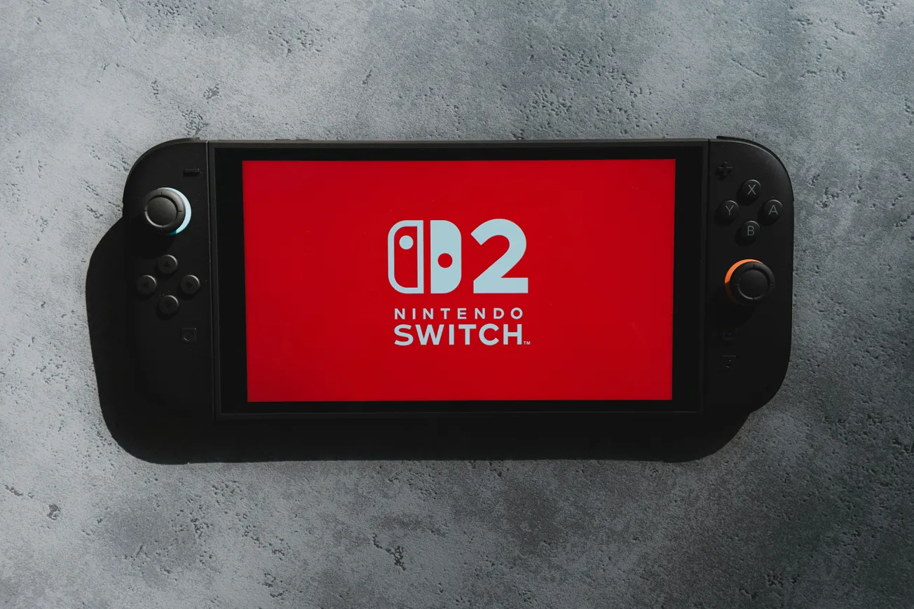 A Nintendo Switch Lite with a red screen displaying the text "Nintendo Switch" and "D2" in bold white letters, set against a gray textured background.