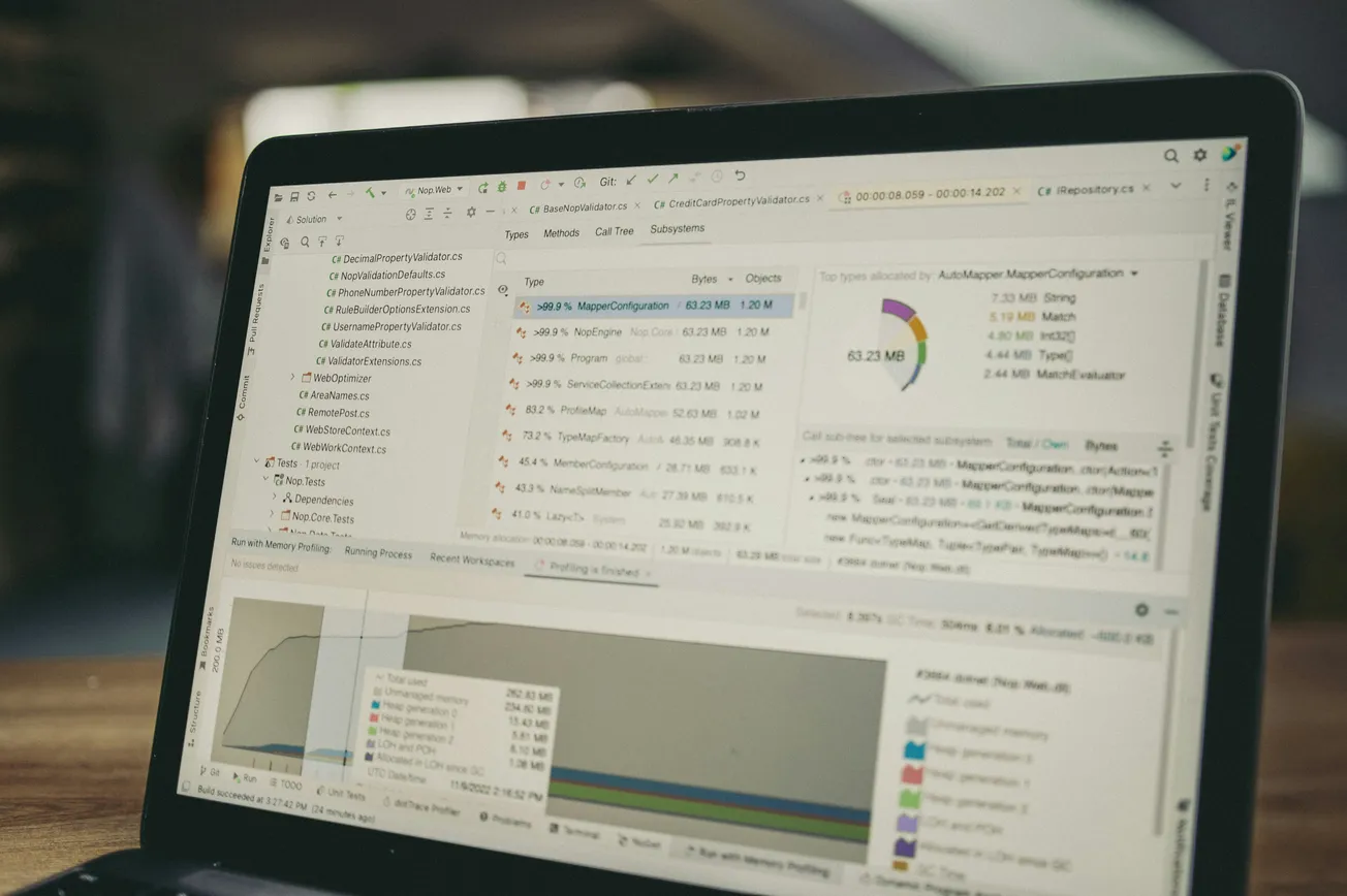 Laptop screen displaying code analysis software with graphs and data charts. The image conveys a focused and tech-oriented atmosphere.